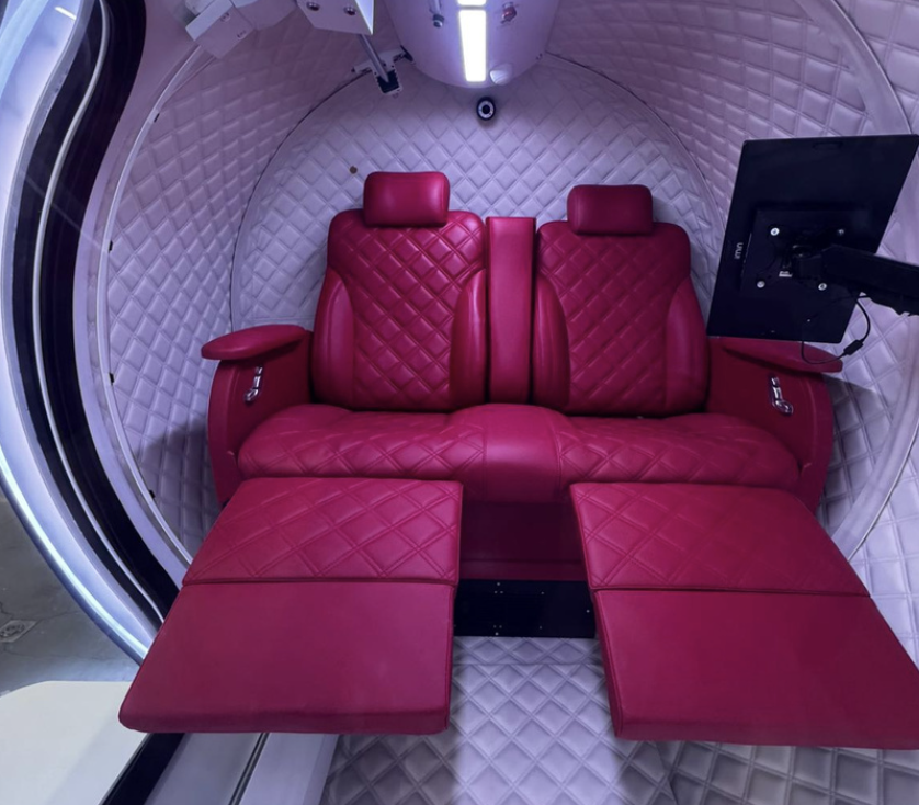 Interiör i Atlantis hyperbar syrgaskammare med röda läderstolar och panoramafönster
